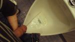 Peeing clear pee in a urinal, to show that urine may be clear after drinking large amounts of water