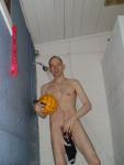 Nude water polo player in shower, hanging his swim brief