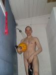 Nude water polo player in shower, hanging his swim brief