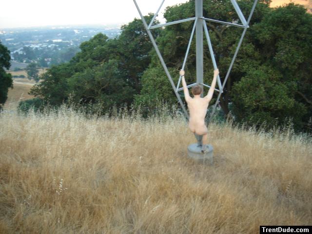 Naked outdoors  - climbing electrical tower in the mountains