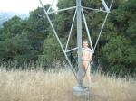 Naked outdoors  - climbing electrical tower in the mountains