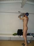 Toned swimmer, nude, hanging up some clothes, in a swim cap (muscles) (gluteus)