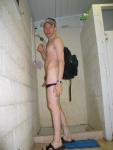 Guy standing nude outside the shower with his gym backpack