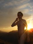 nude at sun rise with the Sun coming over a mountain