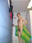 Swimmer drying off in the shower, Nike jammers hanging from a hook (hair chest)