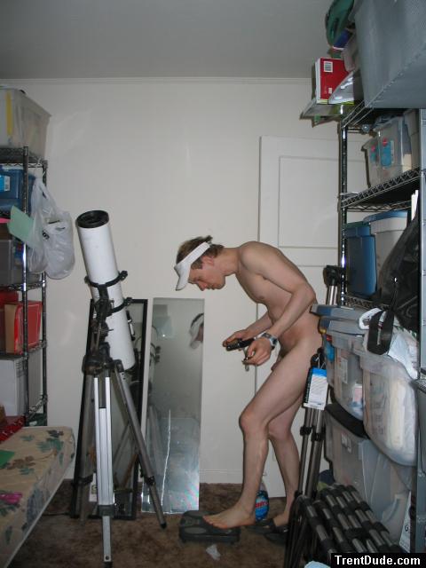 Standing nude by a telescope