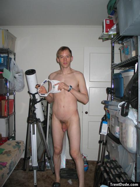 Standing nude by a telescope
