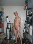 Standing nude by a telescope