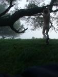 Hanging from a tree branch nude