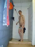 Nude Swimmer pulling down his swim suit in the shower