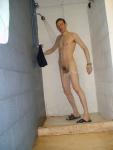 pulling down white swim brief in the shower
