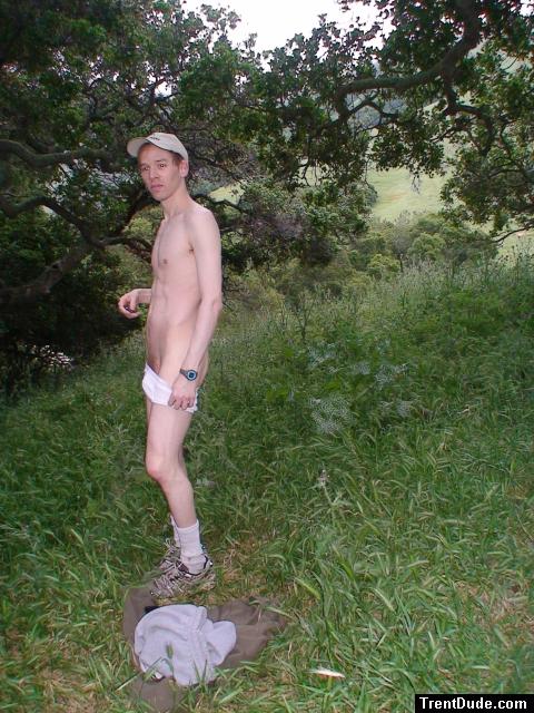 Nude outdoors near a large tree