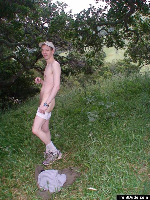 Nude outdoors near a large tree