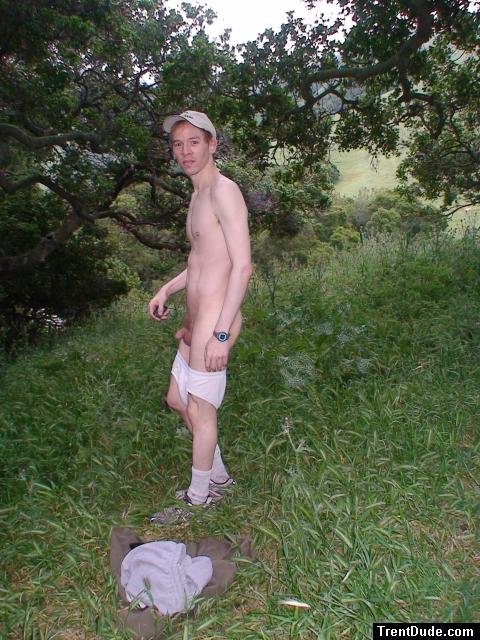 Nude outdoors near a large tree