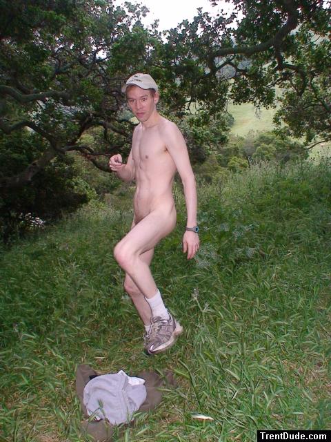 Nude outdoors near a large tree