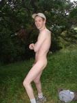Nude outdoors near a large tree