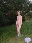 Nude outdoors near a large tree