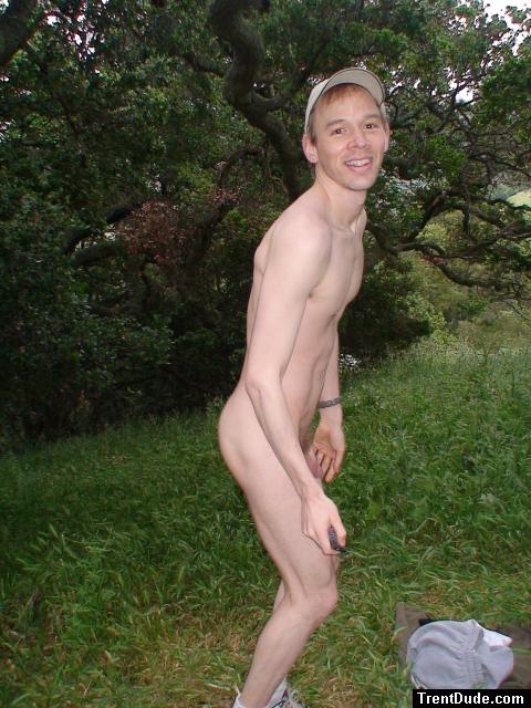 Nude outdoors near a large tree